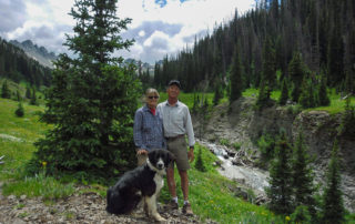 Ed & Lyn Keese in the mountains of Colorado with their dog near a stream