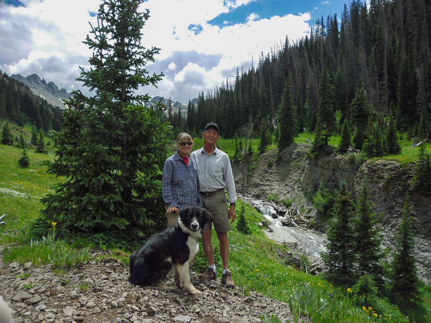 Ed & Lyn Keese in the mountains of Colorado with their dog near a stream