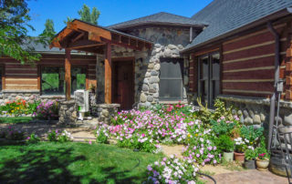 log and stone home with lots of flowers in Montrose, Colorado