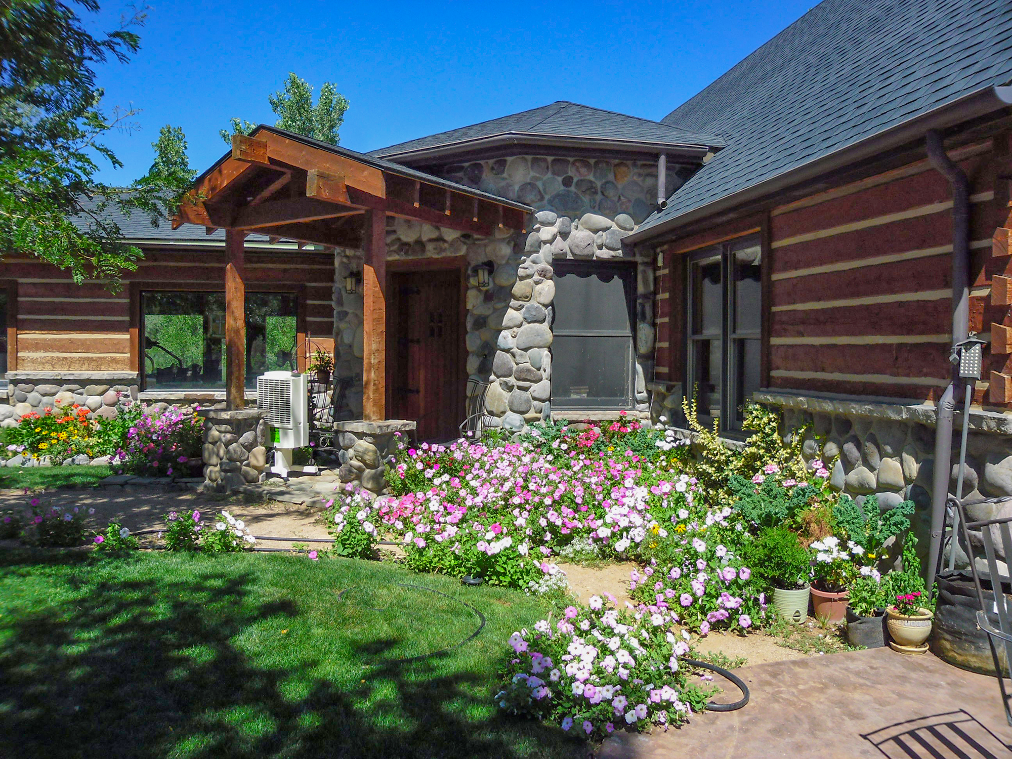 log and stone home with lots of flowers in Montrose, Colorado