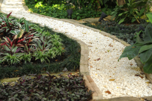 White smooth gravel trail leading away from camera into a green garden.